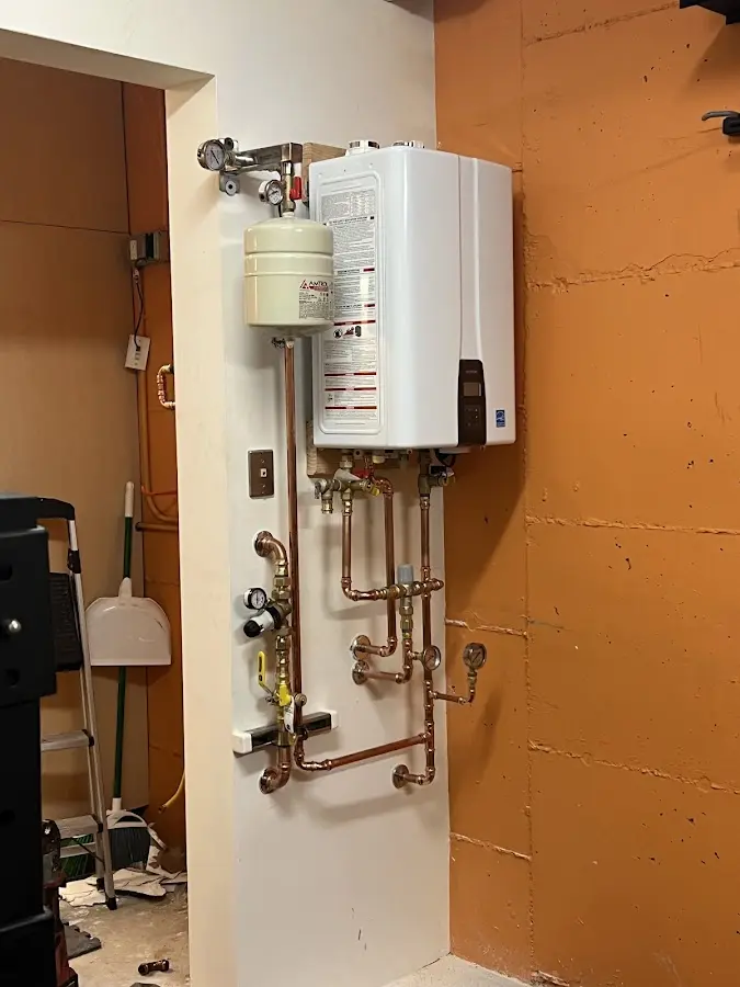 Plumbing technician inspecting water heater connections in San Carlos